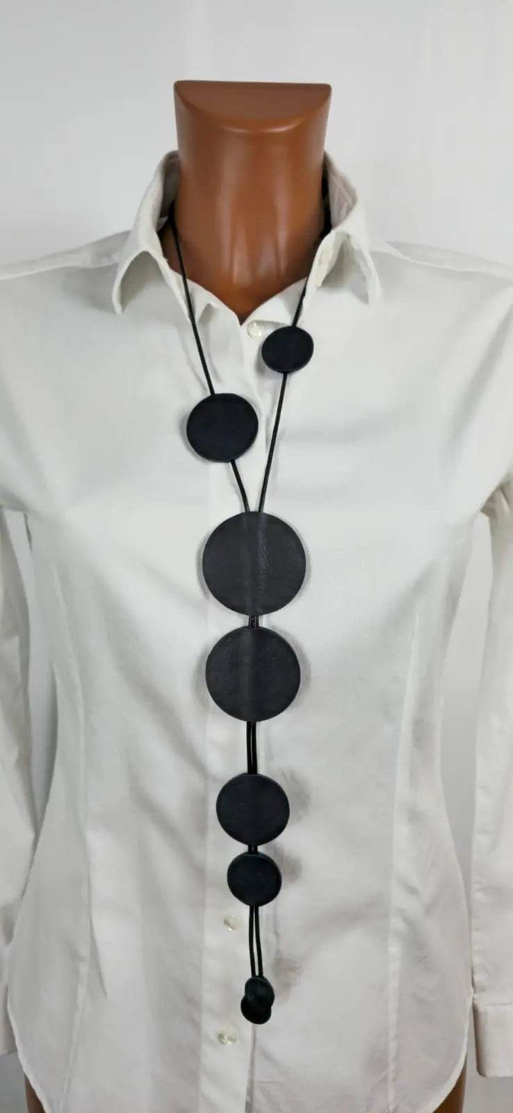 Handmade black and cream Collana Duble face necklace with leather and waxed cord on white shirt